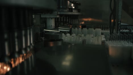 machine produces small plastic containers bottles, in vast chain factory