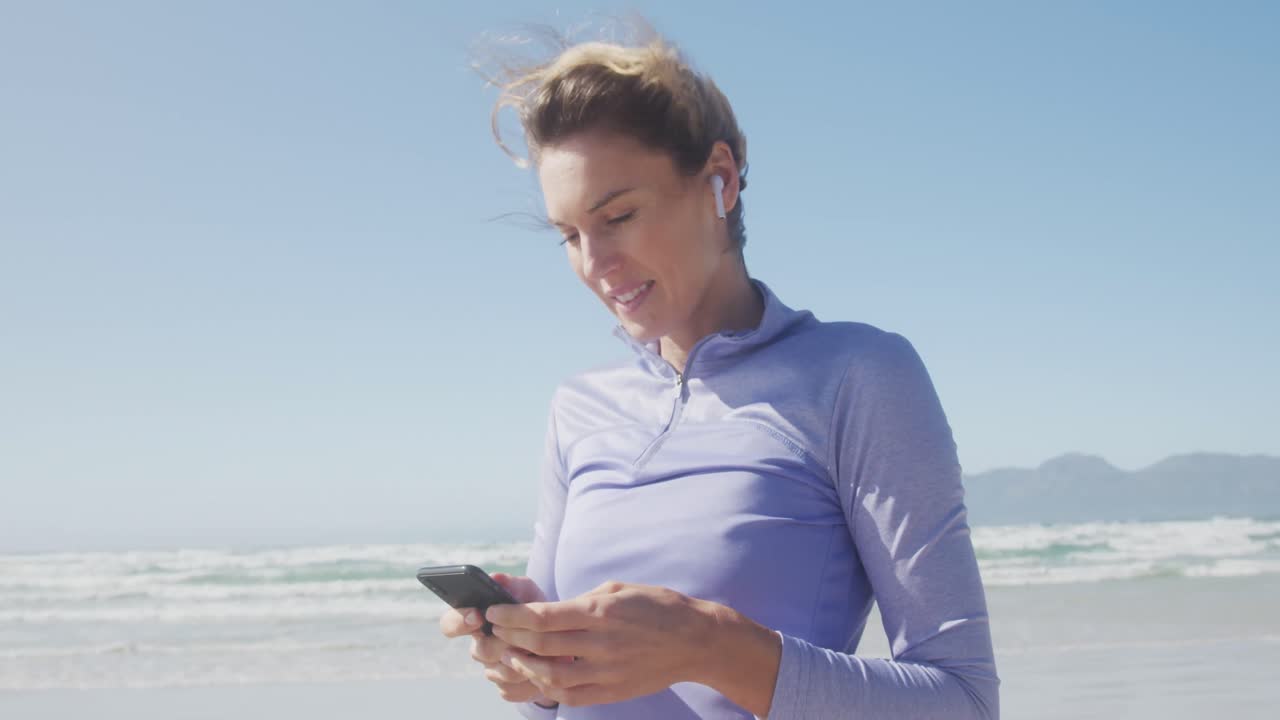 mujer atlética escuchando música en la playa
