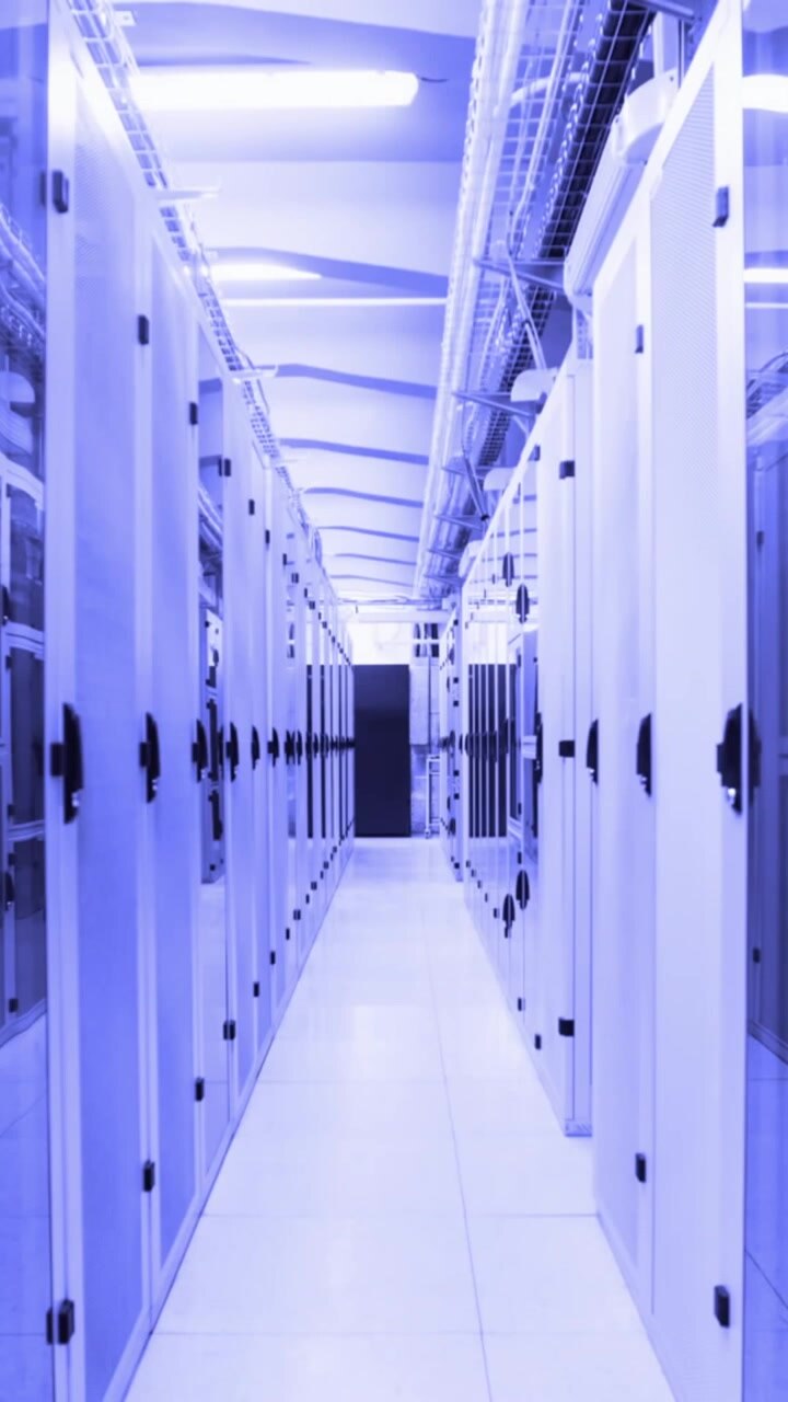 Animation of rainbow lens flare and colorful gradient light trails moving over computer server room