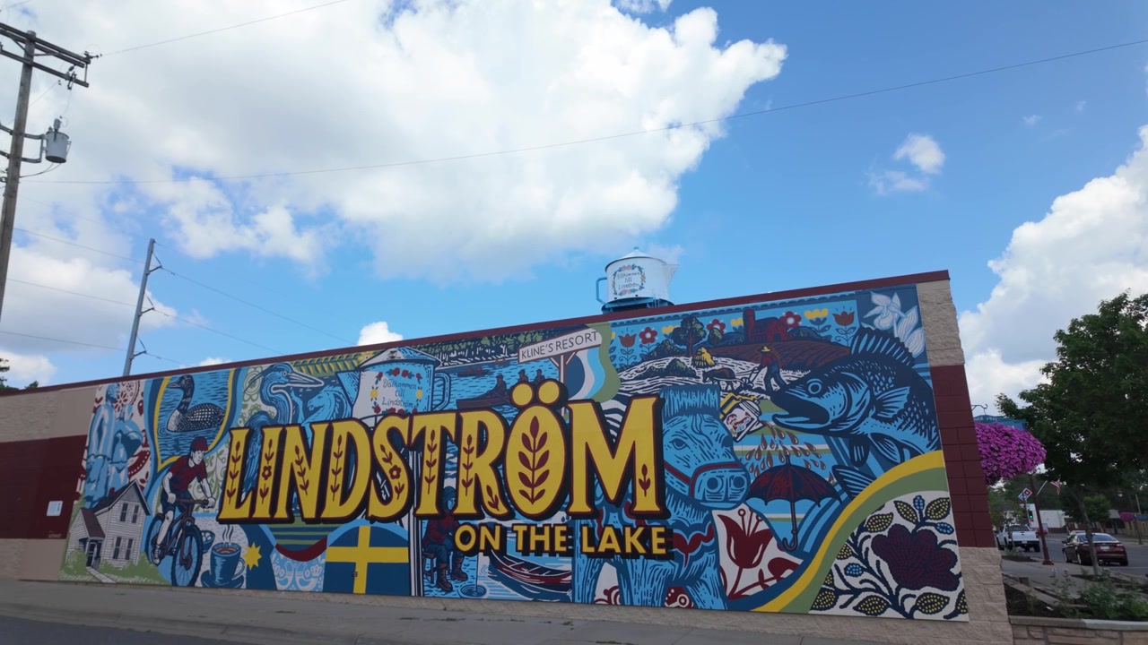 Ampia ripresa in discesa con gimbal della torre dell'acqua a forma di caffettiera svedese che emette vapore a Lindström, Minnesota. 4K.