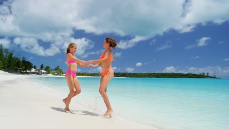 caucasian sisters in swimwear on luxury island beach