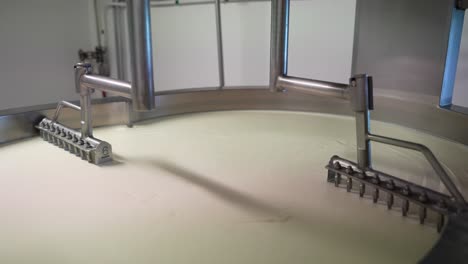 cortadoras de acero sincronizadas cortando queso en una tina industrial en una fábrica de queso