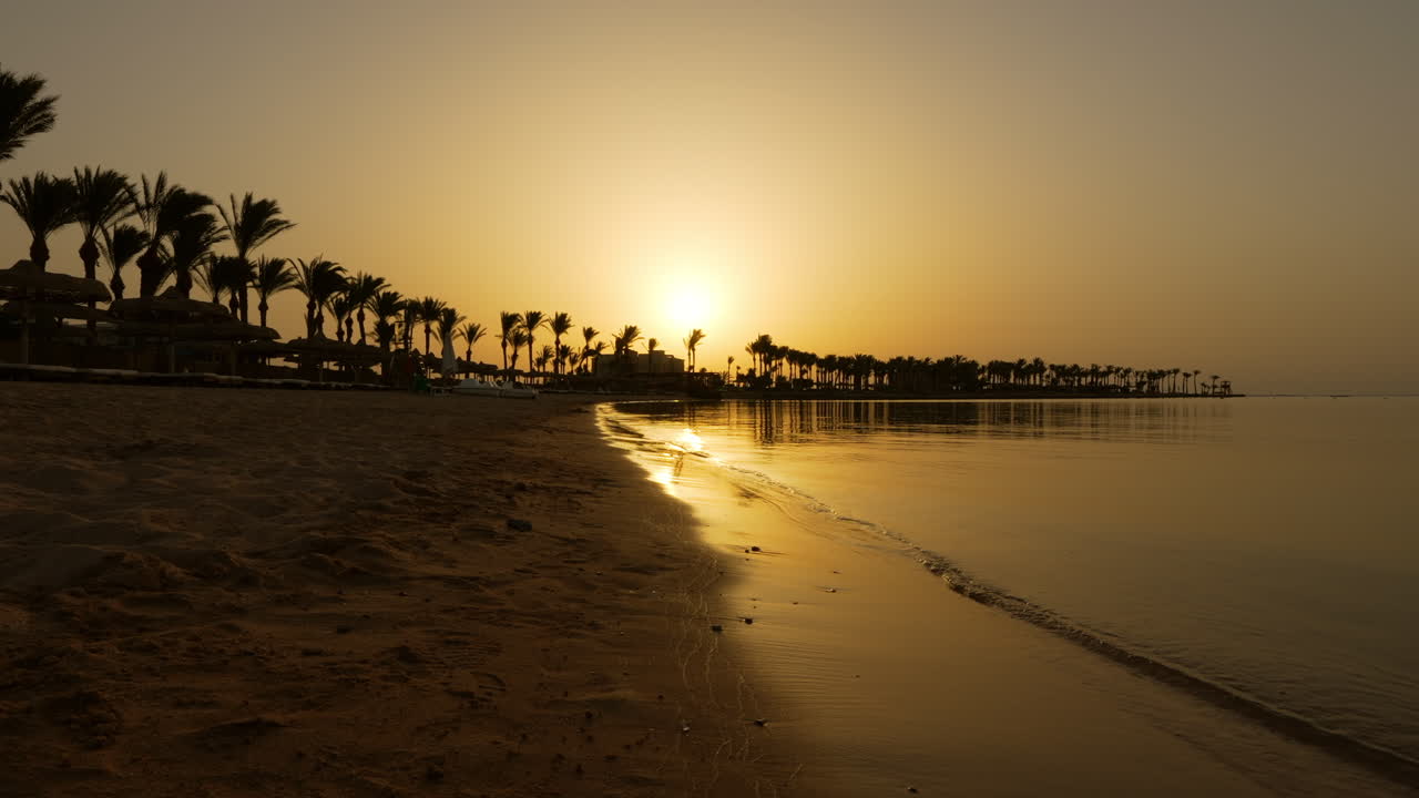 Tramonto caldo con sagome di palme presso il Sentido Palm Royale Resort a Hurghada, Egitto