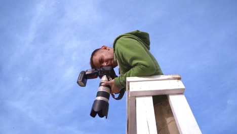 photographer takes picture from watchtower. photographer on sky background