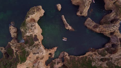 top down aerial view of ponta da piedade with boats on water, lagos town, algarve region, portugal