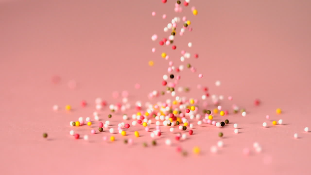 분홍색 표면에 떨어지는 스프링클의 부하