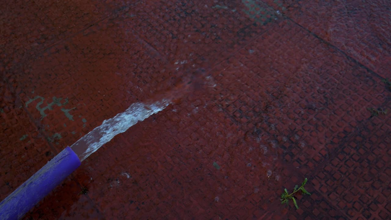 Wasser fließt aus lila Kunststoffrohr