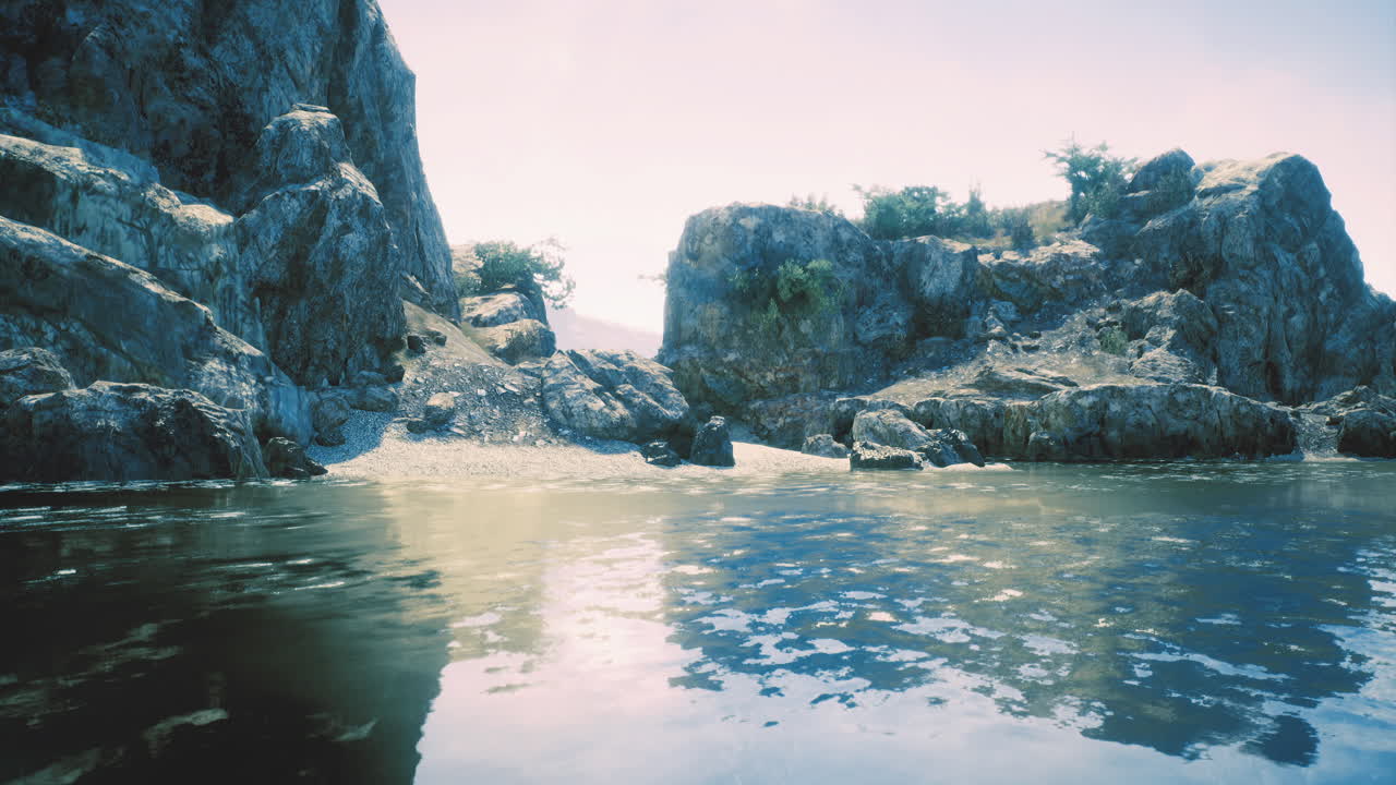Rocky coastal landscape with calm waters and clear skies at midday