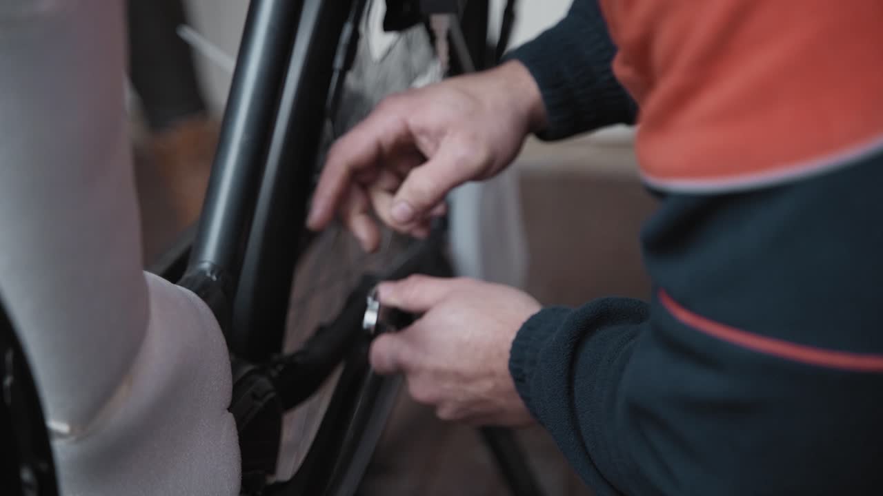 자전거 정비사는 방금 전기 자전거를 구입한 고객을 위해 자전거 페달을 설치하는 크레이크의 볼트를 조입니다.