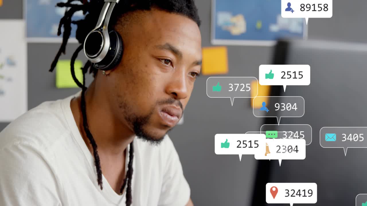 Male content creator typing, starting notification bubbles over monitor while monitoring engagement