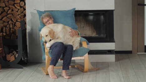 una mujer mayor y un golden retriever relajándose junto a la chimenea.