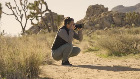 ragazza che fotografa il parco nazionale joshua tree nel deserto della california con una fotocamera sony a1 - angolo basso