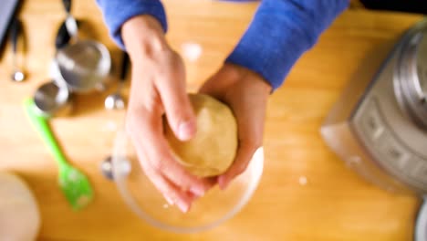 close-up-overhead-shot-of-hands-kneading-dough-into-a-ball