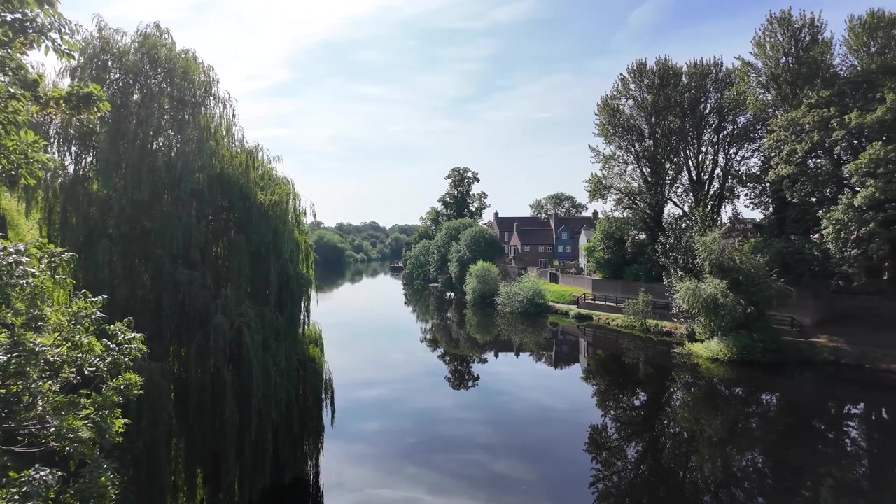 Il fiume Tees scorre oltre case e alberi lungo il fiume a Yarm, North Yorkshire, Inghilterra.