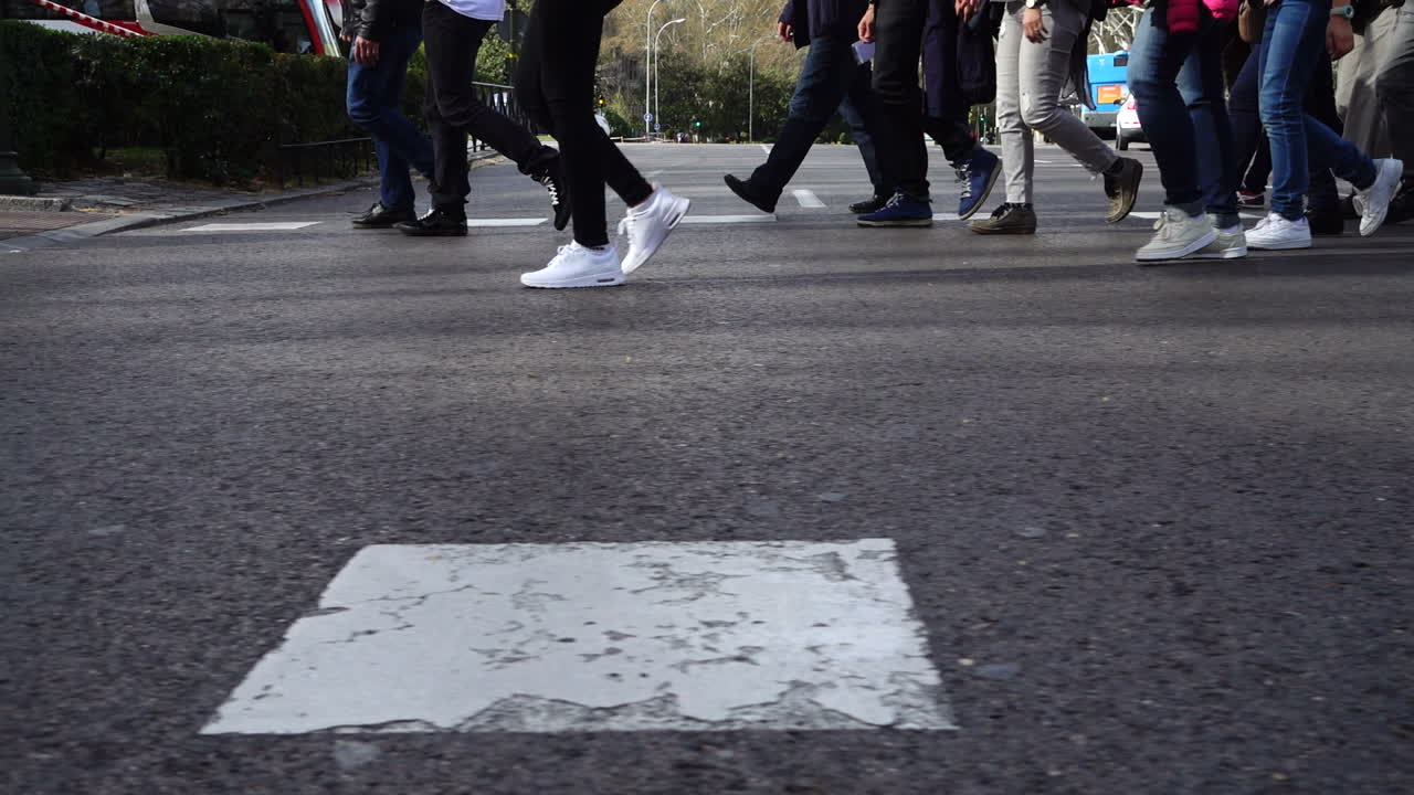 Persone attraversano la strada sulle strisce pedonali. Rallentatore. Pedoni attraversano la strada. Rallentatore.
