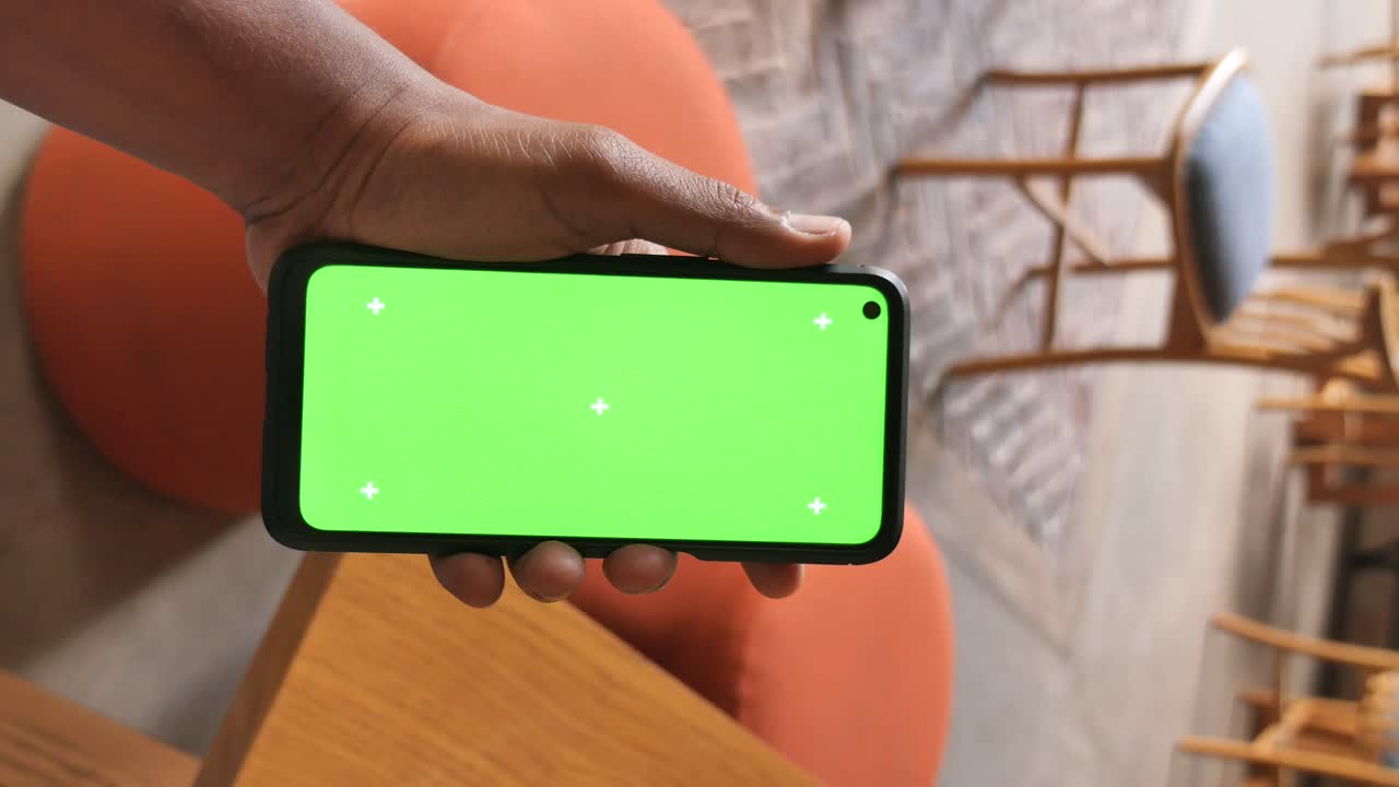 mano sosteniendo un teléfono inteligente con una pantalla verde