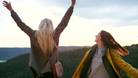 happy friends celebrating sunset view from mountain top