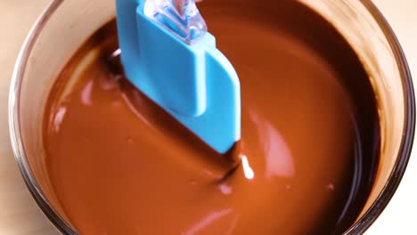 mezclar trozos de chocolate en chocolate derretido suave