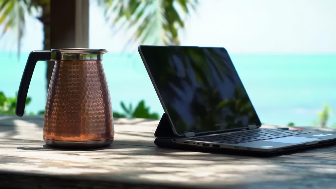A Tropical Workspace: Enjoying Coffee by the Beach with a Laptop Amidst Lush Greenery and Calm Blue Waters