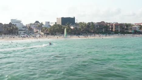 Impresionante-Paisaje-De-Playa-Con-Playa-De-Arena-Y-Complejos-Turísticos.-Gente-Nadando-En-Agua-De-Mar-Turquesa