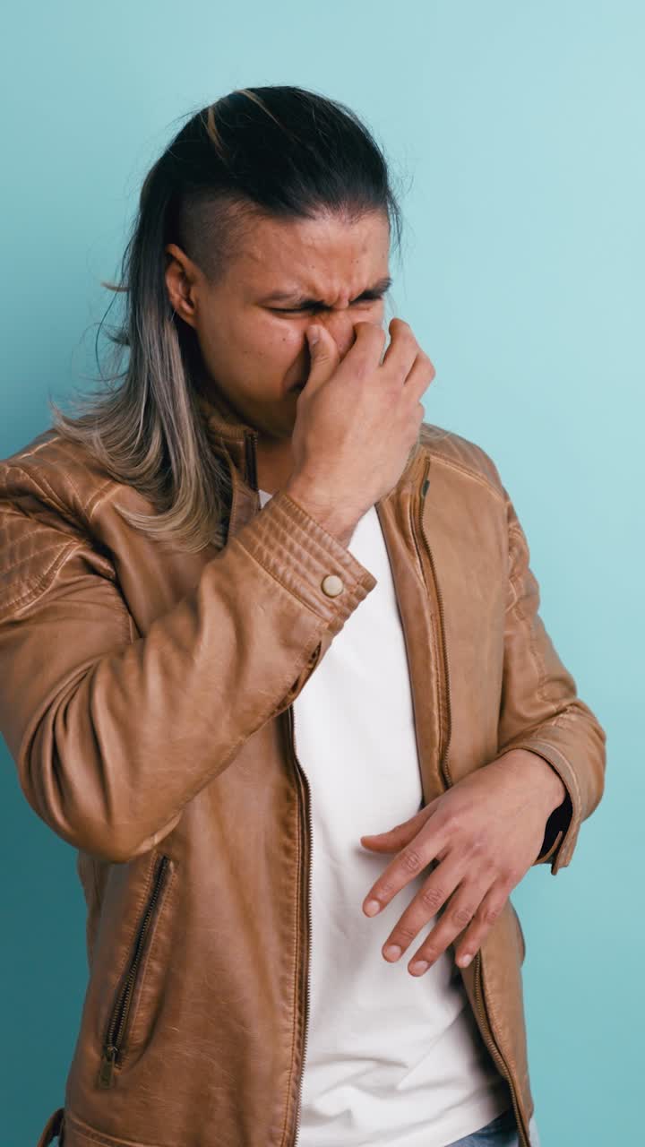 Uomo che si copre bocca e naso con espressione disgustata