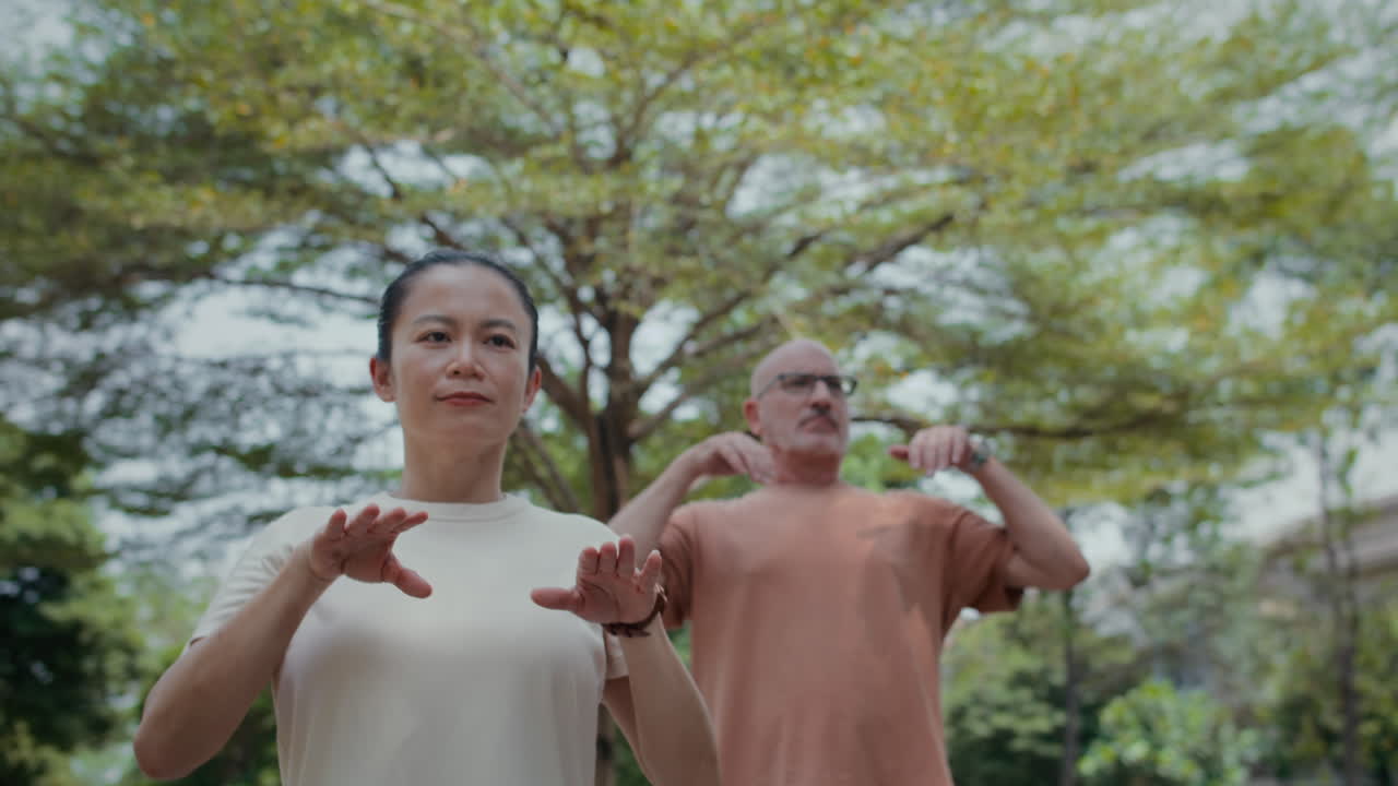 Coach and Client Practicing Tai Chi Movements in park