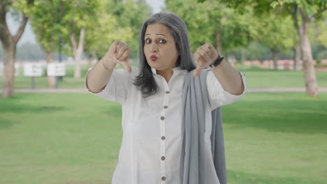 Disappointed-Indian-mother-showing-thumbs-down-in-park