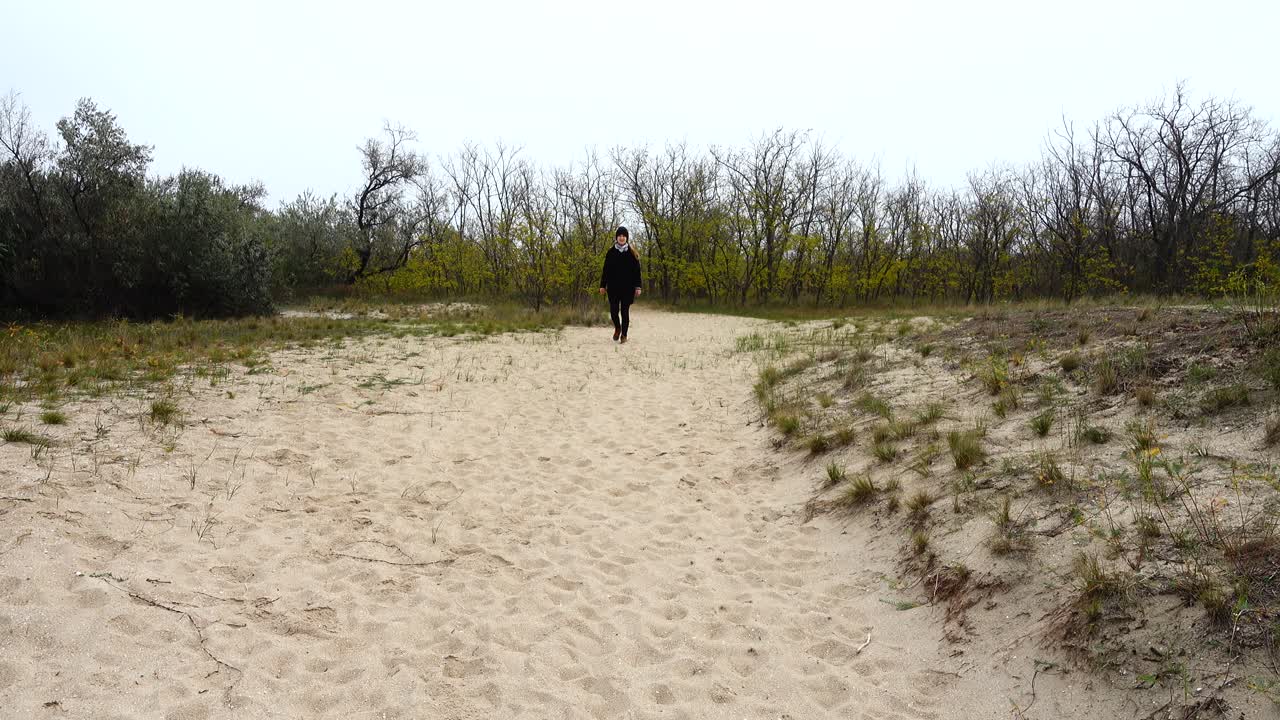 The girl goes on a footpath. Shooting in the fall