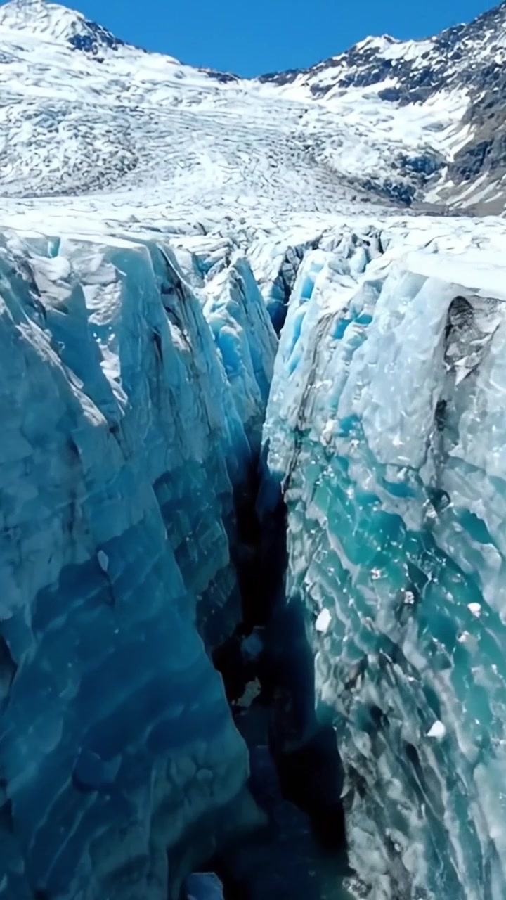 Maestoso Crepaccio Glaciale Rivela Mozzafiato Formazioni di Ghiaccio Blu Sotto Cieli Limpidi, Evidenziando la Bellezza e la Potenza della Natura in un Paesaggio Ghiacciato