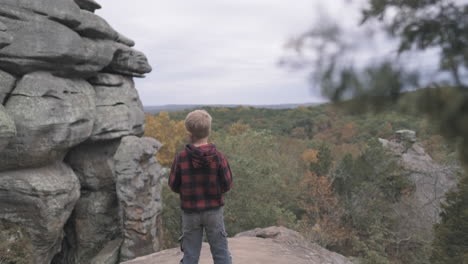 Toddler-gazing-out-over-fall-colored-hills,-Slider-R-to-L,-Slomo