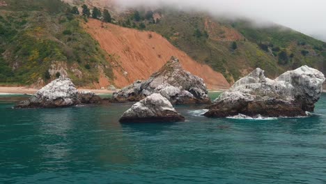 Colorful-coastal-scenery,-jagged-cliffs-in-turquoise-water