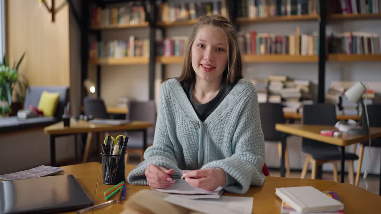 Ragazza adolescente che studia in una caffetteria della biblioteca