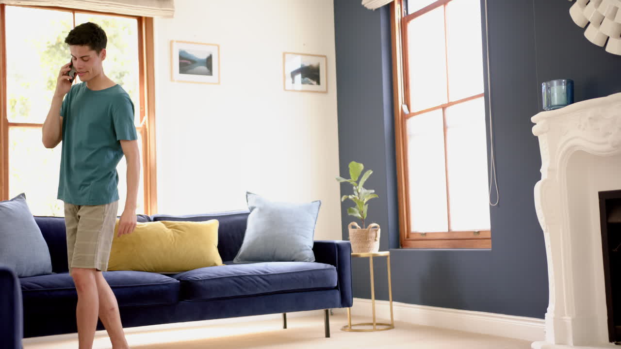 スマートフォンで話す 集中した双人男性 晴れたリビングで歩き回る コピースペース スローモーション