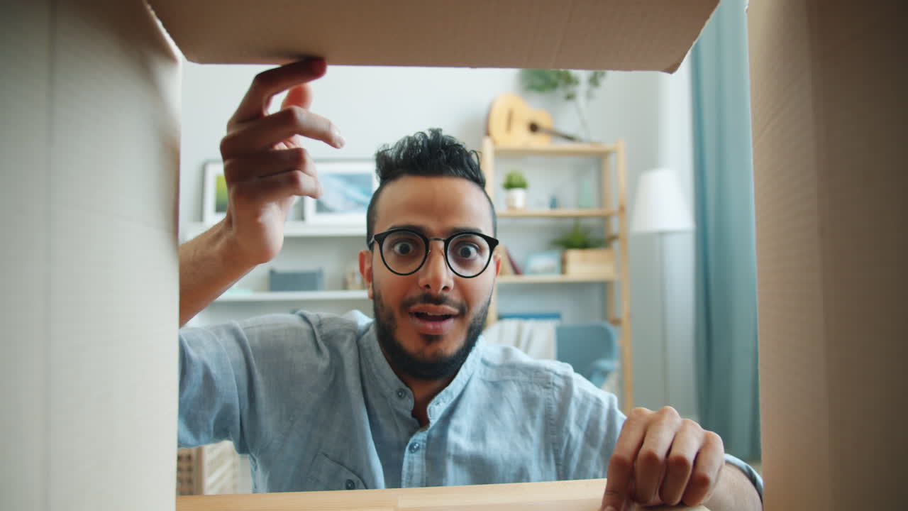 Man Excitedly Opening a Cardboard Box
