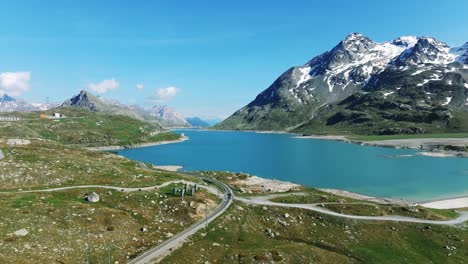 an aerial view of a lake surrounded by mountains under a blue sky