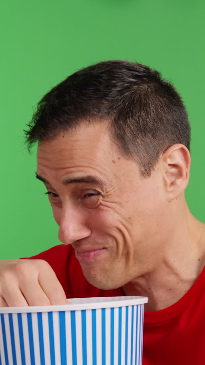 Man enjoying comedy show on television with popcorn