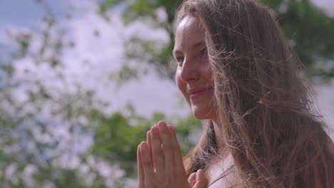 bella mujer practicando yoga y meditando en un parque en un día soleado