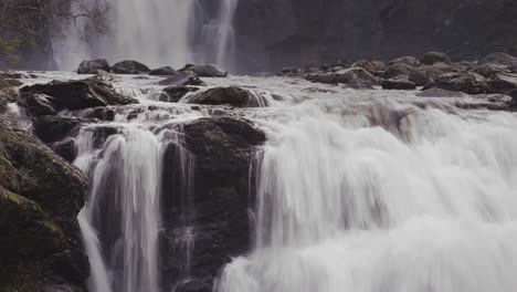 el agua blanca cae en cascada sobre las rocas negras en la cascada storfossen