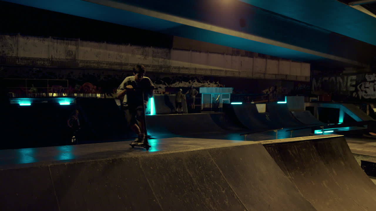 스포티한 십대들이 스쿠터, bmx 자전거를 타고 함께 스케이트파크에서 훈련합니다.