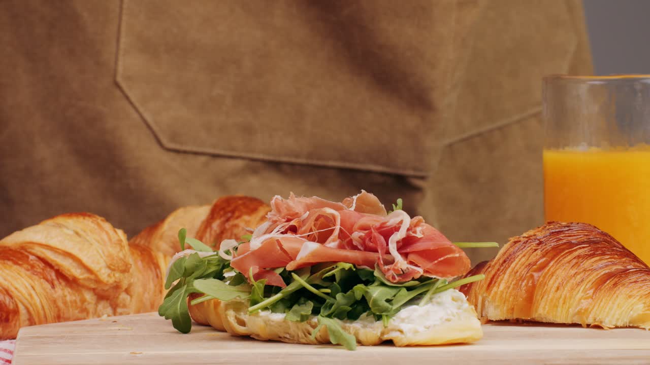 Croissant with jamon ham, Salmon, in Modern Cafe, Top View of Healthy Breakfast in Cafe. English breakfast: fried egg, bacon toast on sandwich.