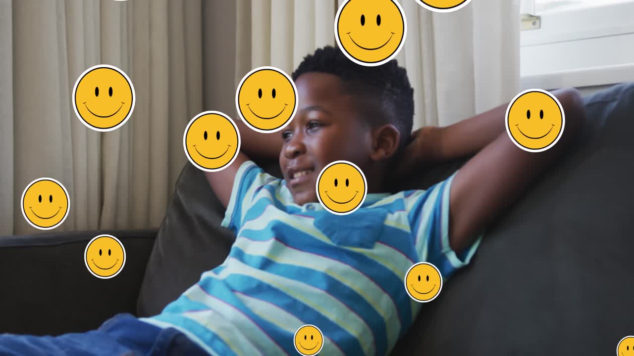 Animation of emoji icons over happy african american boy lying
