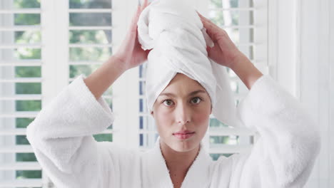 biracial woman wearing towel on head in bathroom, slow motion