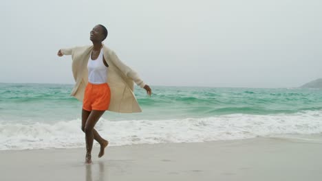 joven mujer afroamericana bailando en la playa 4k