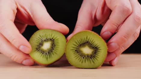halved kiwi in hands