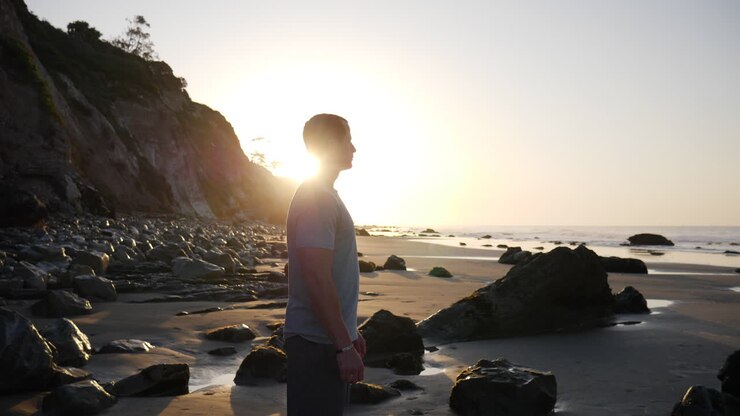 Um atleta forte se preparando para uma corrida matinal e um treino de fitness na praia ao nascer do sol em Santa Barbara, Califórnia
