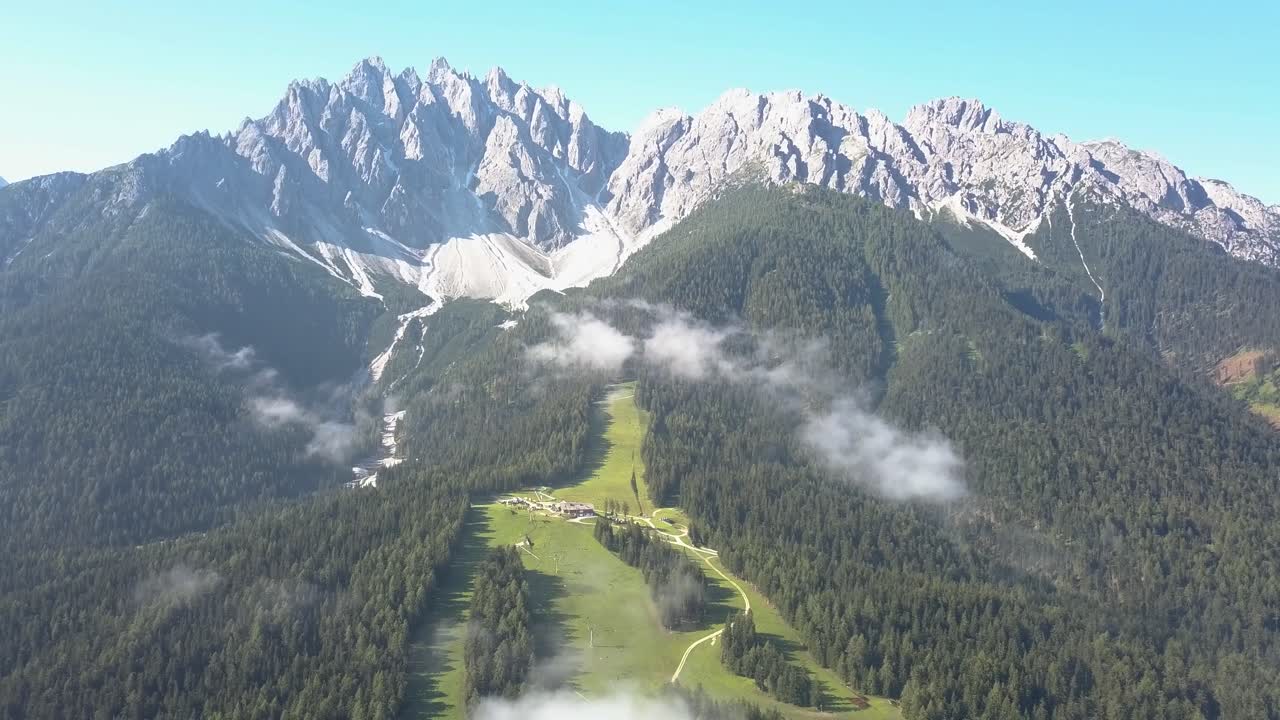 Pista da sci d'estate a Innichen, Alto Adige, verde senza neve, con cime montuose
