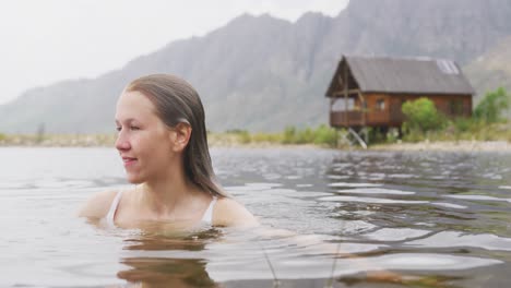 caucasian woman having a good time on a trip to the mountains, wearing a bathing suit and swimming i