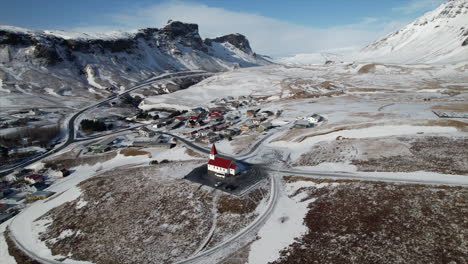 Bewundern-Sie-Die-Filmische-Schönheit-Einer-Kirche-In-Island,-Die-Von-Einer-Drohne-Gefilmt-Wurde,-Während-Sie-Inmitten-Der-Malerischen-Küstenlandschaft-Und-Des-Ruhigen-Strandes-Steht