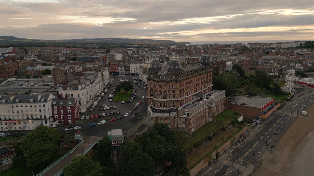 해가 뜨는 황금 시간에 스카르보로 타운 해변 위에서 드론이 촬영되었습니다.