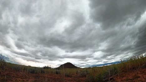 low, wide angle view of storm clouds blowing over the desert landscape in this dramatic time lapse